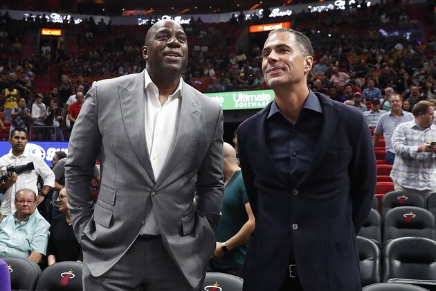 Los Angeles Lakers general manager Rob Pelinka, right, speaks with Lakers president of basketball operations Magic Johnson, left, before before an NBA basketball game against the Miami Heat Sunday, Nov. 18, 2018, in Miami, Fla. (AP Photo/Brynn Anderson)