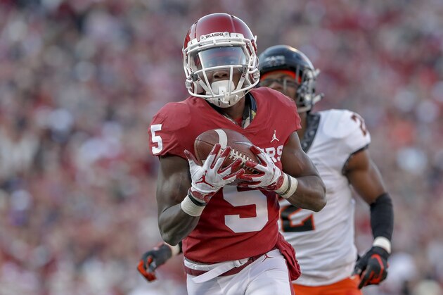Oklahoma wide receiver Marquise Brown (5) runs in for a touchdown ahead of Oklahoma State cornerback Tanner McCalister (2) in the first quarter of an NCAA college football game in Norman, Okla., Saturday, Nov. 10, 2018. (AP Photo/Alonzo Adams)
