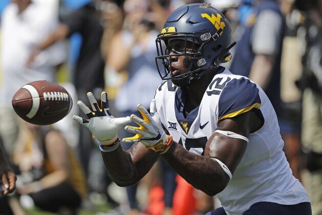 West Virginia's Gary Jennings Jr. (12) warms up before an NCAA college football game against Tennessee in Charlotte, N.C., Saturday, Sept. 1, 2018. (AP Photo/Chuck Burton)