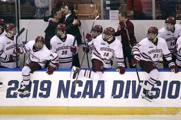 Massachusetts players jump over the boards in celebration after shutting out Notre Dame in an NCAA Division I men's ice hockey regional game in Manchester, N.H., Saturday, March 30, 2019. UMass won 4-0. (AP Photo/Charles Krupa)