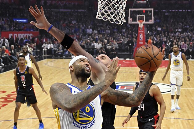 Golden State Warriors center DeMarcus Cousins, left, shoots as Los Angeles Clippers center Marcin Gortat defends during the first half of an NBA basketball game Friday, Jan. 18, 2019, in Los Angeles. (AP Photo/Mark J. Terrill)