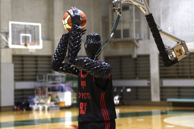 Toyota’s basketball robot Cue 3 demonstrates Monday, April 1, 2019 at a gymnasium in Fuchu, Tokyo. The 207-centimeter (six-foot-10) -tall machine made five of eight three-pointer shots in a demonstration in a Tokyo suburb Monday, a ratio its engineers say is worse than usual. Toyota Motor Corp.’s robot, called Cue 3, computes as a three-dimensional image where the basket is, using sensors on its torso, and adjusts motors inside its arm and knees to give the shot the right angle and propulsion for a swish.(AP Photo/Yuri Kageyama)