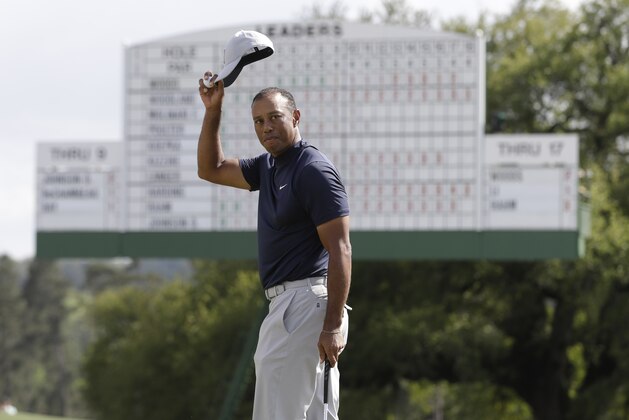 Tiger Woods acknowledges the crowd on the 18th hole during the first round for the Masters golf tournament Thursday, April 11, 2019, in Augusta, Ga. (AP Photo/Marcio Jose Sanchez)