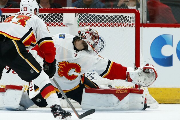 Calgary Flames goaltender Mike Smith, right, gives up a goal to Arizona Coyotes' Clayton Keller as Flames center Sam Bennett (93) looks on during the first period of an NHL hockey game Thursday, March 7, 2019, in Glendale, Ariz. (AP Photo/Ross D. Franklin)