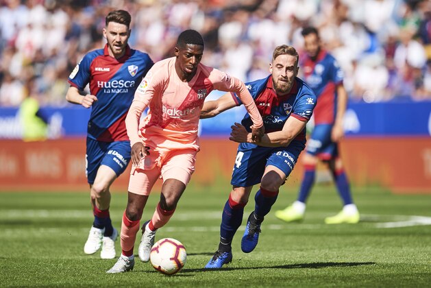 HUESCA, SPAIN - APRIL 13: Ousmane Dembele of FC Barcelona duels for the ball with Jorge Pulido of SD Huesca during the La Liga match between SD Huesca and FC Barcelona at Estadio El Alcoraz on April 13, 2019 in Huesca, Spain. (Photo by Juan Manuel Serrano Arce/Getty Images)