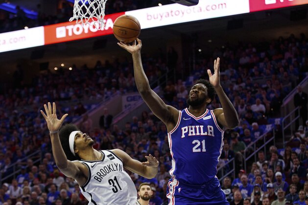 Philadelphia 76ers' Joel Embiid, right, of Cameroon, puts up the shot as he is fouled by Brooklyn Nets' Jarrett Allen, left, during the first half in Game 1 of a first-round NBA basketball playoff series, Saturday, April 13, 2019, in Philadelphia. (AP Photo/Chris Szagola)