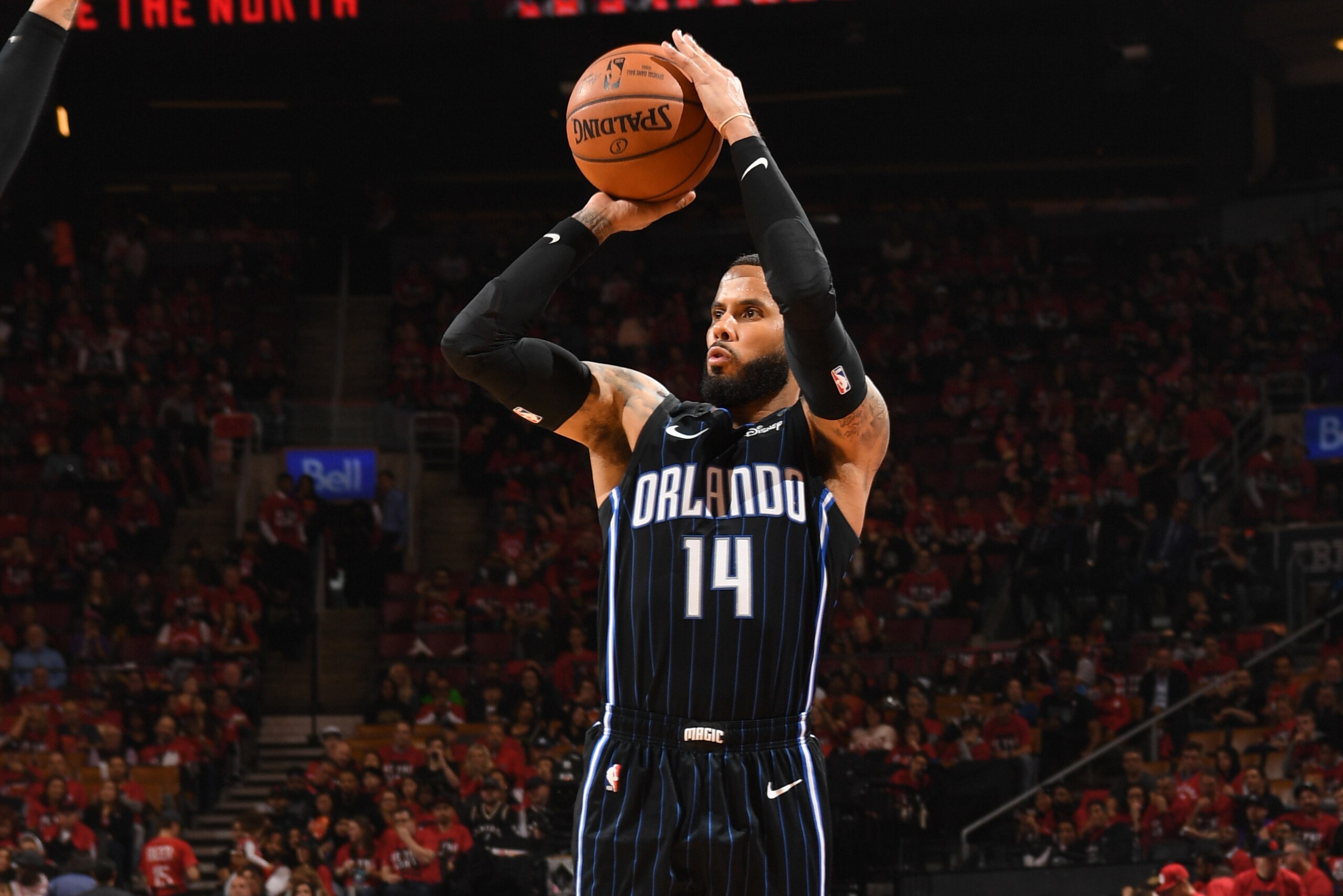 TORONTO, CANADA - APRIL 13: D.J. Augustin #14 of the Orlando Magic shoots a three-pointer against the Toronto Raptors during Game One of Round One of the 2019 NBA Playoffs on April 13, 2019 at the Scotiabank Arena in Toronto, Ontario, Canada.  NOTE TO USER: User expressly acknowledges and agrees that, by downloading and or using this Photograph, user is consenting to the terms and conditions of the Getty Images License Agreement.  Mandatory Copyright Notice: Copyright 2019 NBAE (Photo by Ron Turenne/NBAE via Getty Images)