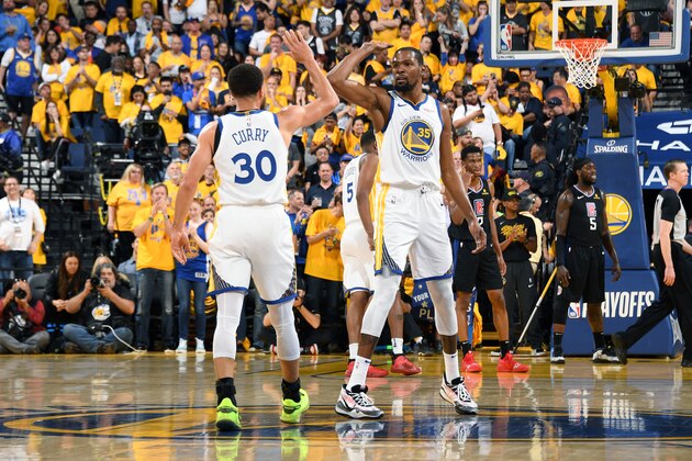 OAKLAND, CA - APRIL 13: Stephen Curry #30 and Kevin Durant #35 of the Golden State Warriors high five during Game One of Round One of the 2019 NBA Playoffs against the LA Clippers on April 13, 2019 at ORACLE Arena in Oakland, California. NOTE TO USER: User expressly acknowledges and agrees that, by downloading and/or using this photograph, user is consenting to the terms and conditions of Getty Images License Agreement. Mandatory Copyright Notice: Copyright 2019 NBAE (Photo by Andrew D. Bernstein/NBAE via Getty Images)