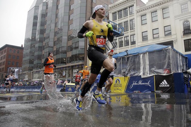 Timothy McFadden, of Boston, splashes through a puddle after finishing the 122nd Boston Marathon in the rain on Monday, April 16, 2018, in Boston. (AP Photo/Elise Amendola)