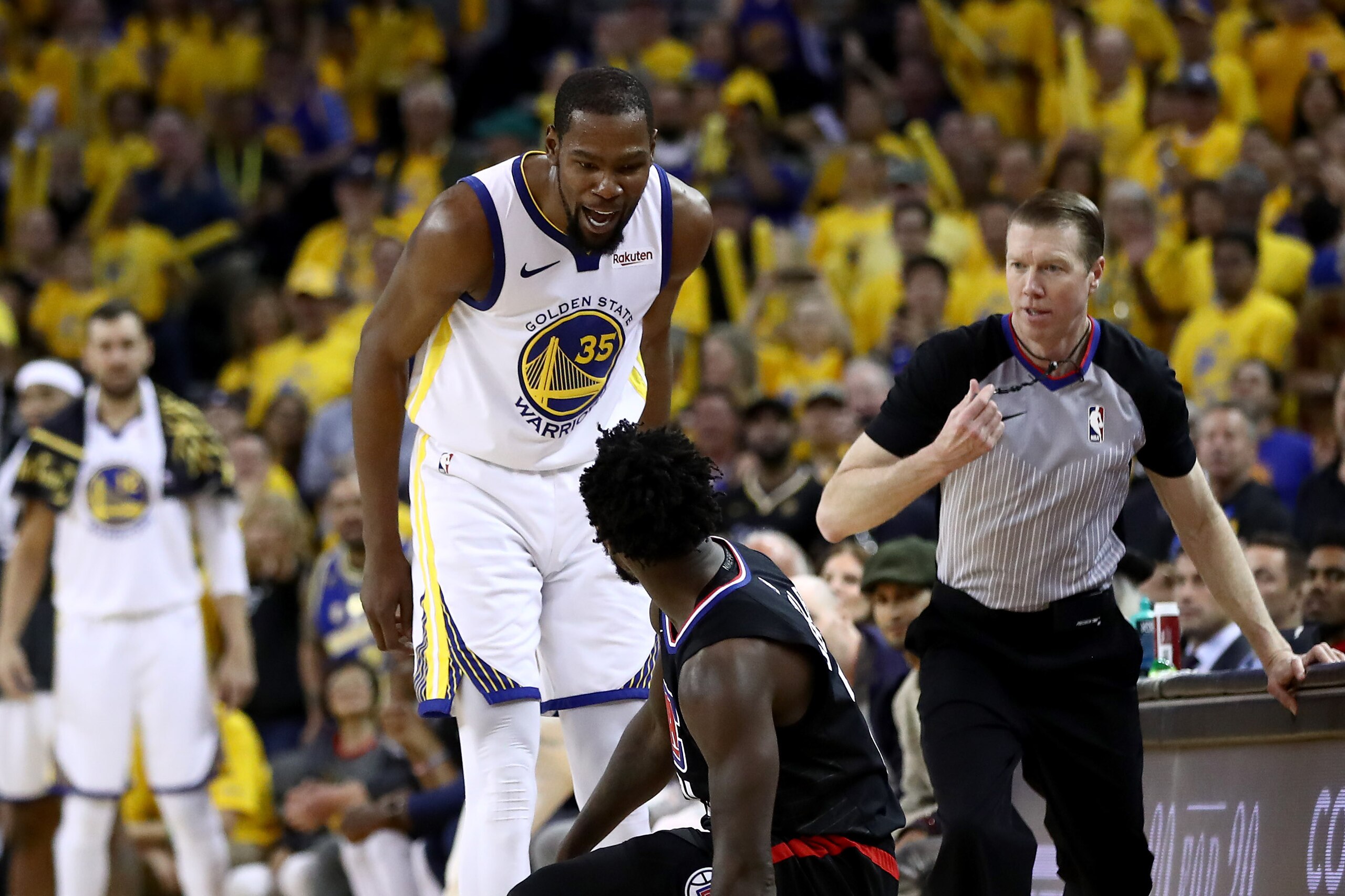 OAKLAND, CALIFORNIA - APRIL 13:   Kevin Durant #35 of the Golden State Warriors has words with Patrick Beverley #21 of the LA Clippers during Game One of the first round of the 2019 NBA Western Conference Playoffs at ORACLE Arena on April 13, 2019 in Oakland, California. Both players were ejected after the play.  NOTE TO USER: User expressly acknowledges and agrees that, by downloading and or using this photograph, User is consenting to the terms and conditions of the Getty Images License Agreement. (Photo by Ezra Shaw/Getty Images)