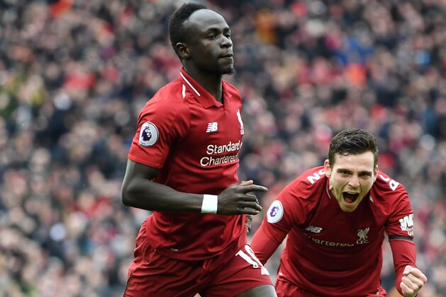 LIVERPOOL, ENGLAND - APRIL 14:  Sadio Mane of Liverpool celebrates after scoring his team's first goal with Andy Robertson during the Premier League match between Liverpool FC and Chelsea FC at Anfield on April 14, 2019 in Liverpool, United Kingdom. (Photo by Michael Regan/Getty Images)