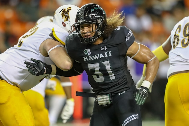 HONOLULU, HI - OCTOBER 06: Jahlani Tavai #31 of the Hawaii Rainbow Warriors gets around Zach Wallace #72 of the Wyoming Cowboys during the second half at Aloha Stadium on October 06, 2018 in Honolulu, Hawaii. (Photo by Darryl Oumi/Getty Images)