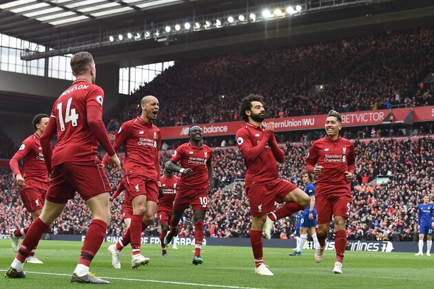 TOPSHOT - Liverpool's Egyptian midfielder Mohamed Salah (C) celebrates with teammates after scoring their second goal during the English Premier League football match between Liverpool and Chelsea at Anfield in Liverpool, north west England on April 14, 2019. (Photo by Paul ELLIS / AFP) / RESTRICTED TO EDITORIAL USE. No use with unauthorized audio, video, data, fixture lists, club/league logos or 'live' services. Online in-match use limited to 120 images. An additional 40 images may be used in extra time. No video emulation. Social media in-match use limited to 120 images. An additional 40 images may be used in extra time. No use in betting publications, games or single club/league/player publications. /         (Photo credit should read PAUL ELLIS/AFP/Getty Images)