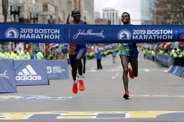 Lawrence Cherono, left, of Kenya, runs to the finish line to win the 123rd Boston Marathon in front of Lelisa Desisa, of Ethiopia, right, on Monday, April 15, 2019, in Boston. (AP Photo/Winslow Townson)