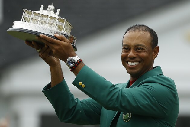 Tiger Woods wears his green jacket holding the winning trophy after the final round for the Masters golf tournament Sunday, April 14, 2019, in Augusta, Ga. (AP Photo/Matt Slocum)