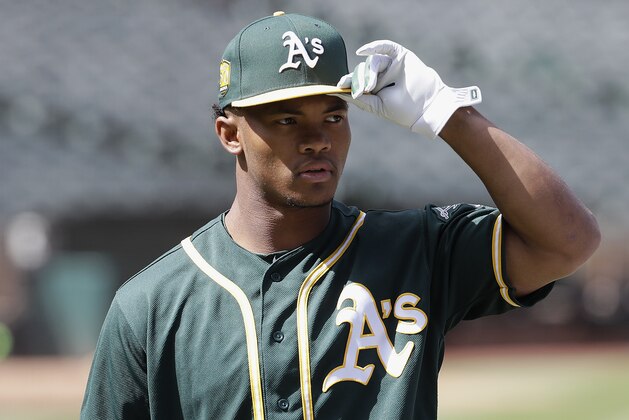 FILE - In this June 15, 2018, file photo, Oakland Athletics draft pick Kyler Murray looks on before a baseball game between the Athletics and the Los Angeles Angels, in Oakland, Calif. Murray's locker remained empty on Monday, Feb. 11, 2019, in the spring training clubhouse of the Oakland Athletics, who say they are uncertain when or if the Heisman Trophy winner will report to the baseball team he signed with last summer. Billy Beane, Oakland’s executive vice president of baseball operation, said talks are continuing with Murray, who may drop baseball to pursue an NFL career. (AP Photo/Jeff Chiu, File)