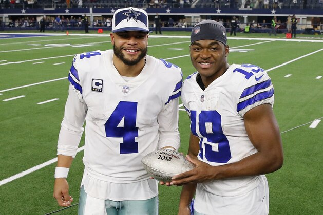 Dallas Cowboys quarterback Dak Prescott (4) and wide receiver Amari Cooper (19) pose for photographs after an NFL football game between the Dallas Cowboys and Washington Redskins in Arlington, Texas, Thursday, Nov. 22, 2018. The Dallas Cowboys won 31-23. (AP Photo/Roger Steinman)