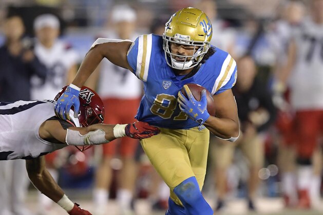 UCLA tight end Caleb Wilson, right, breaks a tackle by Arizona safety Tristan Cooper during the second half of an NCAA college football game Saturday, Oct. 20, 2018, in Pasadena, Calif. UCLA won 31-30. (AP Photo/Mark J. Terrill)