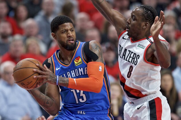 Oklahoma City Thunder forward Paul George, left, looks to pass the ball around Portland Trail Blazers forward Al-Farouq Aminu during the first half of Game 2 of an NBA basketball first-round playoff series Tuesday, April 16, 2019, in Portland, Ore. (AP Photo/Craig Mitchelldyer)