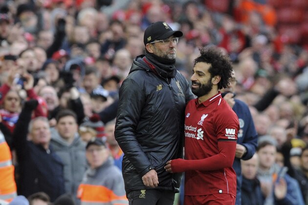 Liverpool manager Juergen Klopp, left, hugs Liverpool's Mohamed Salah during the English Premier League soccer match between Liverpool and Chelsea at Anfield stadium in Liverpool, England, Sunday, April 14, 2019. (AP Photo/Rui Vieira)