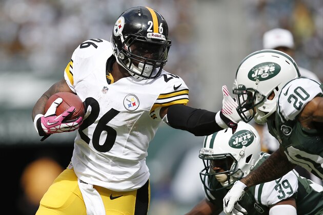 Pittsburgh Steelers running back Le'Veon Bell (26) stiff-arms New York Jets' Kyle Wilson (20) as Antonio Allen (39) falls down on the play during the first half of an NFL football game Sunday, Oct. 13, 2013, in East Rutherford, N.J.  (AP Photo/Kathy Willens)