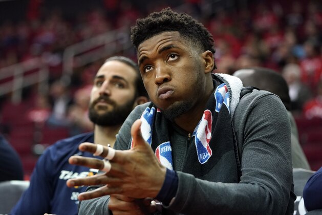 Utah Jazz guard Donovan Mitchell, right, watches the final moments of Game 2 of a first-round NBA basketball playoff series against the Houston Rockets in Houston, Wednesday, April 17, 2019. At left is Jazz guard Ricky Rubio. The Rockets won 118-98 and lead the series 2-0. (AP Photo/David J. Phillip)