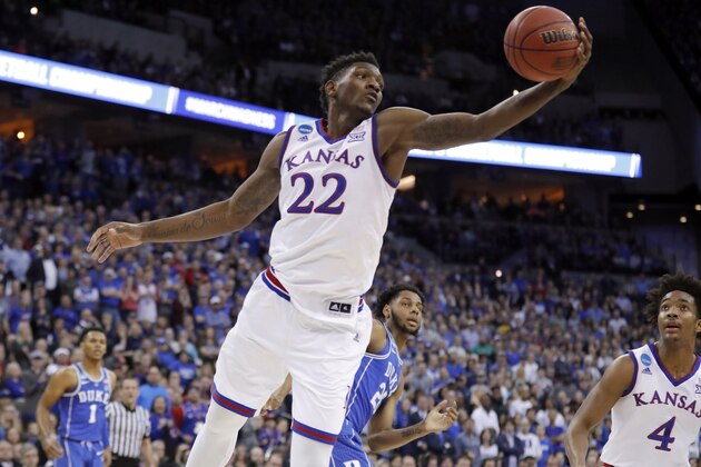 Kansas' Silvio De Sousa reaches for a rebound during the first half of a regional final game against Duke in the NCAA men's college basketball tournament Sunday, March 25, 2018, in Omaha, Neb. (AP Photo/Charlie Neibergall)