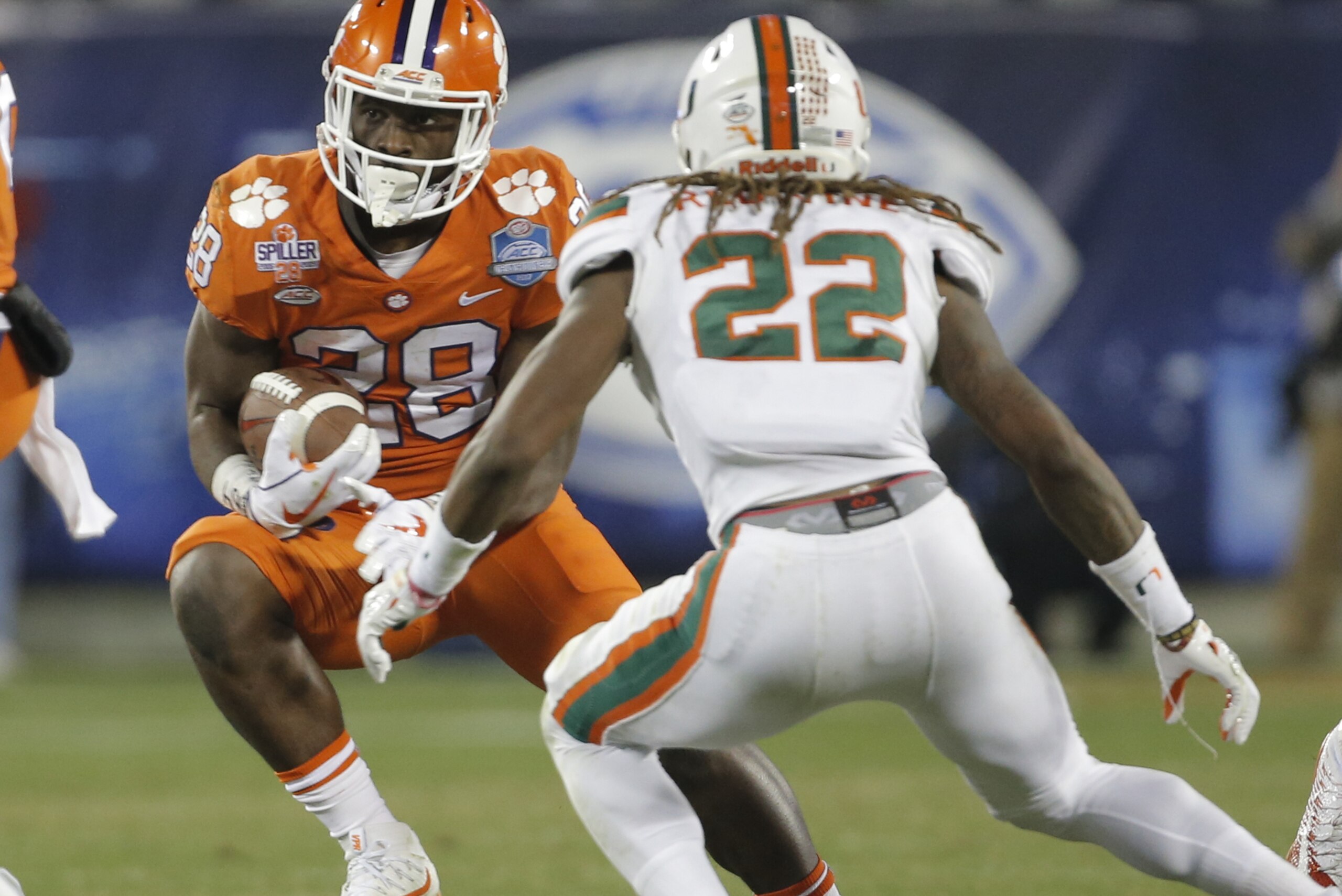Clemson's Tavien Feaster (28) runs against Miami's Sheldrick Redwine (22) during the second half of the Atlantic Coast Conference championship NCAA college football game in Charlotte, N.C., Saturday, Dec. 2, 2017. (AP Photo/Bob Leverone)