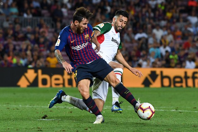 BARCELONA, SPAIN - AUGUST 18:  Lionel Messi of FC Barcelona competes for the ball with Ruben Duarte of Deportivo Alaves during the La Liga match between FC Barcelona and Deportivo Alaves at Camp Nou on August 18, 2018 in Barcelona, Spain.  (Photo by David Ramos/Getty Images)