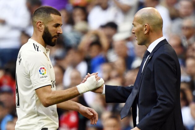 TOPSHOT - Real Madrid's French forward Karim Benzema (L) greets Real Madrid's French coach Zinedine Zidane as he leaves the pitch during the Spanish league football match between Real Madrid CF and RC Celta de Vigo at the Santiago Bernabeu stadium in Madrid on March 16, 2019. (Photo by GABRIEL BOUYS / AFP)        (Photo credit should read GABRIEL BOUYS/AFP/Getty Images)