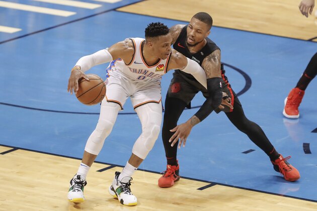 Oklahoma City Thunder guard Russell Westbrook (0) drives to the basket as Portland Trail Blazers guard Damian Lillard (0) defends in the first half of Game 4 of an NBA basketball first-round playoff series Sunday, April 21, 2019, in Oklahoma City. (AP Photo/Alonzo Adams)