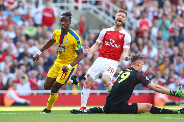 LONDON, ENGLAND - APRIL 21: Wilfried Zaha of Crystal Palace celebrates after scoring his team's second goal whilst Shkodran Mustafi of Arsenal reacts during the Premier League match between Arsenal FC and Crystal Palace at Emirates Stadium on April 21, 2019 in London, United Kingdom. (Photo by Warren Little/Getty Images)