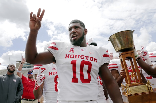 Houston Cougars defensive tackle Ed Oliver does the Cougar Paw with his team mates and the Bayou Bucket trophy after defeating the Rice Owls after a NCAA college football game Saturday, Sep. 1, 2018, in Houston. (AP Photo/Michael Wyke)