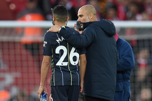 Manchester City's Spanish manager Pep Guardiola talks with Manchester City's Algerian midfielder Riyad Mahrez as they leave the pitch following the English Premier League football match between Liverpool and Manchester City at Anfield in Liverpool, north west England on October 7, 2018. - The match ended in a draw 0-0. (Photo by Paul ELLIS / AFP) / RESTRICTED TO EDITORIAL USE. No use with unauthorized audio, video, data, fixture lists, club/league logos or 'live' services. Online in-match use limited to 120 images. An additional 40 images may be used in extra time. No video emulation. Social media in-match use limited to 120 images. An additional 40 images may be used in extra time. No use in betting publications, games or single club/league/player publications. /         (Photo credit should read PAUL ELLIS/AFP/Getty Images)