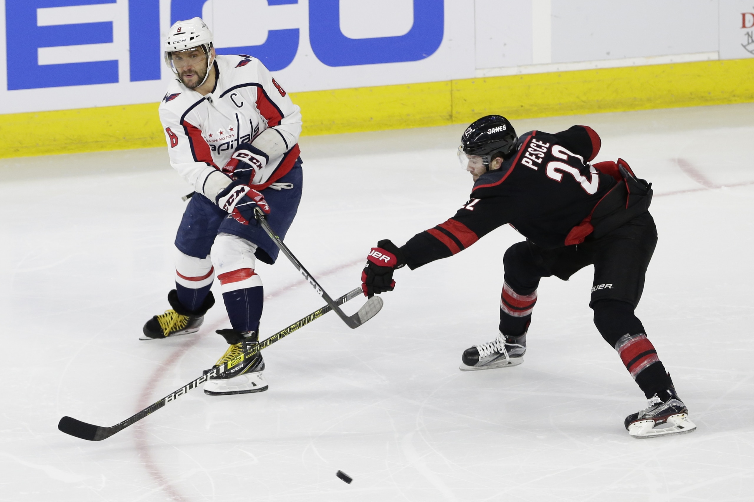 Carolina Hurricanes' Brett Pesce (22) chases Washington Capitals' Alex Ovechkin (8) during the second period of Game 6 of an NHL hockey first-round playoff series in Raleigh, N.C., Monday, April 22, 2019. (AP Photo/Gerry Broome)