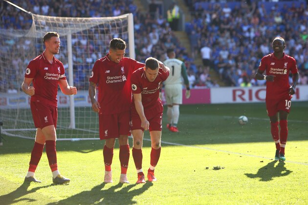 Liverpool's English midfielder James Milner (C) celebrates scoring their second goal from the penalty spot during the English Premier League football match between between Cardiff City and Liverpool at Cardiff City Stadium in Cardiff, south Wales on April 21, 2019. (Photo by GEOFF CADDICK / AFP) / RESTRICTED TO EDITORIAL USE. No use with unauthorized audio, video, data, fixture lists, club/league logos or 'live' services. Online in-match use limited to 120 images. An additional 40 images may be used in extra time. No video emulation. Social media in-match use limited to 120 images. An additional 40 images may be used in extra time. No use in betting publications, games or single club/league/player publications. /         (Photo credit should read GEOFF CADDICK/AFP/Getty Images)