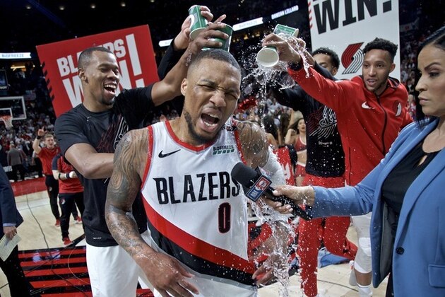 Portland Trail Blazers' Damian Lillard (0) gets water poured on him by teammates Rodney Hood, left, and guard Evan Turner, right, after Game 5 of an NBA basketball first-round playoff series against the Oklahoma City Thunder, Tuesday, April 23, 2019, in Portland, Ore. The Trail Blazers won 118-115. (AP Photo/Craig Mitchelldyer)