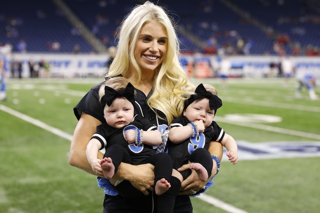 FILE - In this Sept. 24, 2017, file photo, Kelly Stafford, wife of Detroit Lions quarterback Matthew Stafford, holds the couple's twins Sawyer, left, and Chandler during pre-game of an NFL football game against the Atlanta Falcons, in Detroit. Kelly Stafford plans to have surgery to remove a brain tumor. Stafford shared the details Wednesday, April 3, 2019, on her Instagram account. She says an MRI showed the tumor on cranial nerves after she had vertigo spells within the last year. (AP Photo/Rick Osentoski, File)