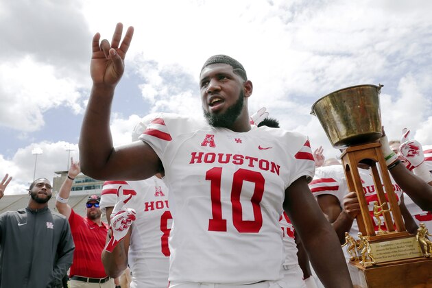 Houston Cougars defensive tackle Ed Oliver does the Cougar Paw with his teammates and the Bayou Bucket trophy after defeating Rice in a NCAA college football game Saturday, Sept. 1, 2018, in Houston. (AP Photo/Michael Wyke)