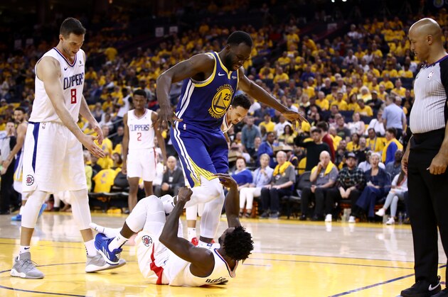 OAKLAND, CALIFORNIA - APRIL 24:  Draymond Green #23 of the Golden State Warriors gets tangled wth Patrick Beverley #21 of the LA Clippers after Green was called for an offensive foul during Game Five of the first round of the 2019 NBA Western Conference Playoffs at ORACLE Arena on April 24, 2019 in Oakland, California. NOTE TO USER: User expressly acknowledges and agrees that, by downloading and or using this photograph, User is consenting to the terms and conditions of the Getty Images License Agreement. (Photo by Ezra Shaw/Getty Images)