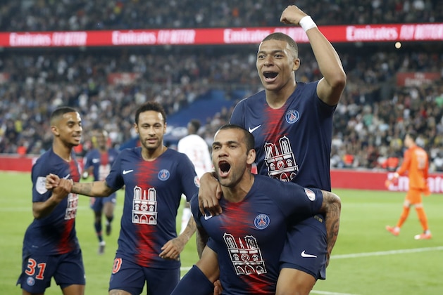 PSG's Kylian Mbappe, top, celebrates with teammate Dani Alves after scoring the third goal during the French League One soccer match between Paris-Saint-Germain and Monaco at the Parc des Princes stadium in Paris, Sunday April 21, 2019. (AP Photo/Michel Euler)