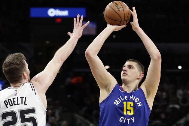 Denver Nuggets center Nikola Jokic (15) shoots over San Antonio Spurs center Jakob Poeltl (25) during the first half of Game 6 of an NBA basketball playoff series, Thursday, April 25, 2019, in San Antonio. (AP Photo/Eric Gay)