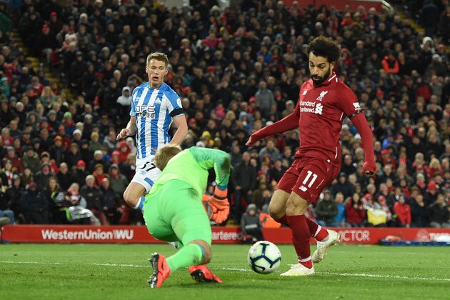 Liverpool's Egyptian midfielder Mohamed Salah (R) scores the team's fifth goal during the English Premier League football match between Liverpool and Huddersfield at Anfield in Liverpool, north west England on April 26, 2019. (Photo by Oli SCARFF / AFP) / RESTRICTED TO EDITORIAL USE. No use with unauthorized audio, video, data, fixture lists, club/league logos or 'live' services. Online in-match use limited to 120 images. An additional 40 images may be used in extra time. No video emulation. Social media in-match use limited to 120 images. An additional 40 images may be used in extra time. No use in betting publications, games or single club/league/player publications. /         (Photo credit should read OLI SCARFF/AFP/Getty Images)