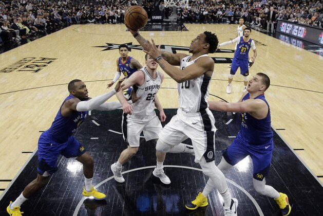 San Antonio Spurs guard DeMar DeRozan (10) drives to the basket against Denver Nuggets forward Paul Millsap (4) and center Nikola Jokic (15) during the second half of Game 6 of an NBA basketball playoff series, Thursday, April 25, 2019, in San Antonio. San Antonio won 120-103. (AP Photo/Eric Gay)