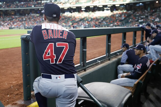 Cleveland Indians pitcher Trevor Bauer (47) watches from the dugout with the name