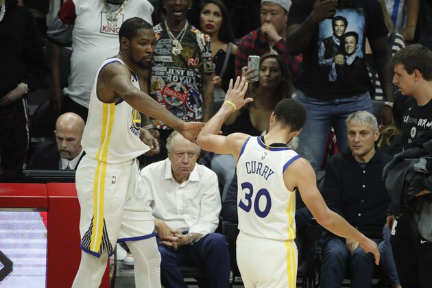 Golden State Warriors' Kevin Durant, left, and Stephen Curry high-five as they walks off the court during the second half in Game 6 of a first-round NBA basketball playoff series against the Los Angeles Clippers Friday, April 26, 2019, in Los Angeles. The Warriors won 129-110. (AP Photo/Jae C. Hong)