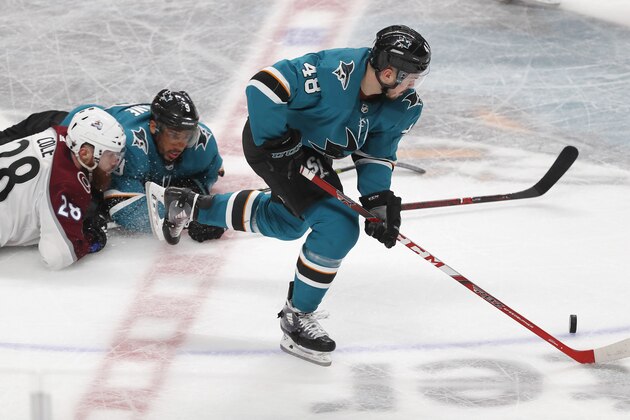 Colorado Avalanche's Ian Cole (28) and San Jose Sharks' Evander Kane (9) battle for the puck as San Jose Sharks' Tomas Hertl (48) moves the puck down the ice in the third period of Game 1 of an NHL hockey second-round playoff series at the SAP Center in San Jose, Calif., on Friday, April 26, 2019. (AP Photo/Josie Lepe)