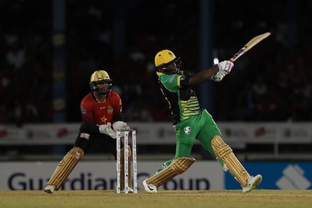 PORT OF SPAIN, TRINIDAD AND TOBAGO - AUGUST 10:  In this handout image provided by CPL T20, Andre Russell of Jamaica Tallawahs hits six runs as Denesh Ramdin of Trinbago Knight Riders looks on during the Hero Caribbean Premier League match between Trinbago Knight Riders and Jamaica Tallawahs at Queen's Park Oval on August 10, 2018 in Port of Spain, Trinidad And Tobago. (Photo by Ashley Allen - CPL T20/Getty Images)