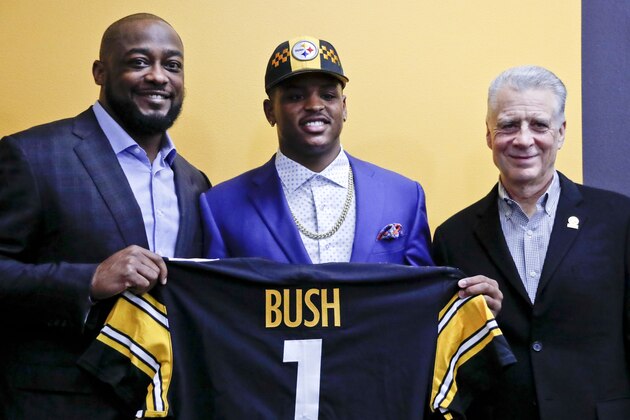 Pittsburgh Steelers' first round draft choice in the 2019 NFL football draft, Devin Bush, center, stands with team President Art Rooney II, right, and head coach Mike Tomlin, left, as he holds his draft day team jersey after a news conference,Friday, April 26, 2019, in Pittsburgh. (AP Photo/Keith Srakocic)