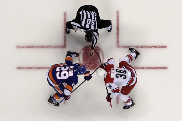 NHL linesman Scott Cherrey (50) drops the puck between New York Islanders center Brock Nelson (29) and Carolina Hurricanes center Patrick Brown (36) during the second period of Game 2 of an NHL hockey second-round playoff series, Sunday, April 28, 2019, in New York. The Hurricanes won 2-1. (AP Photo/Julio Cortez)